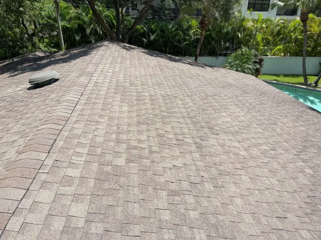 Roof replacement crew tearing off old shingles on a Hillsborough County home