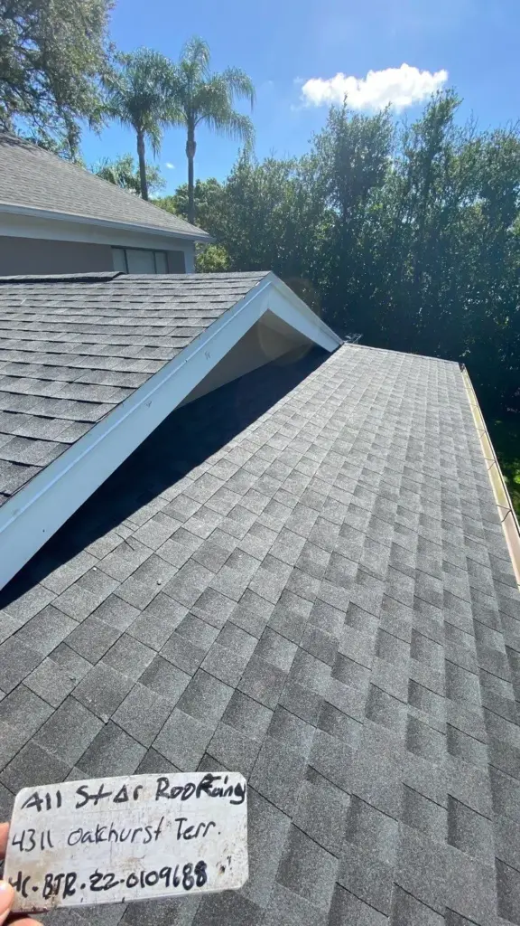 Roofing crew tearing off old shingles during roof replacement in Hillsborough County, FL