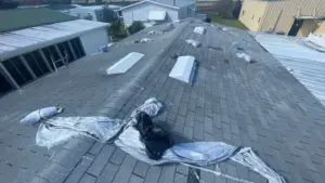 Crew installing new roofing material on a Polk County home