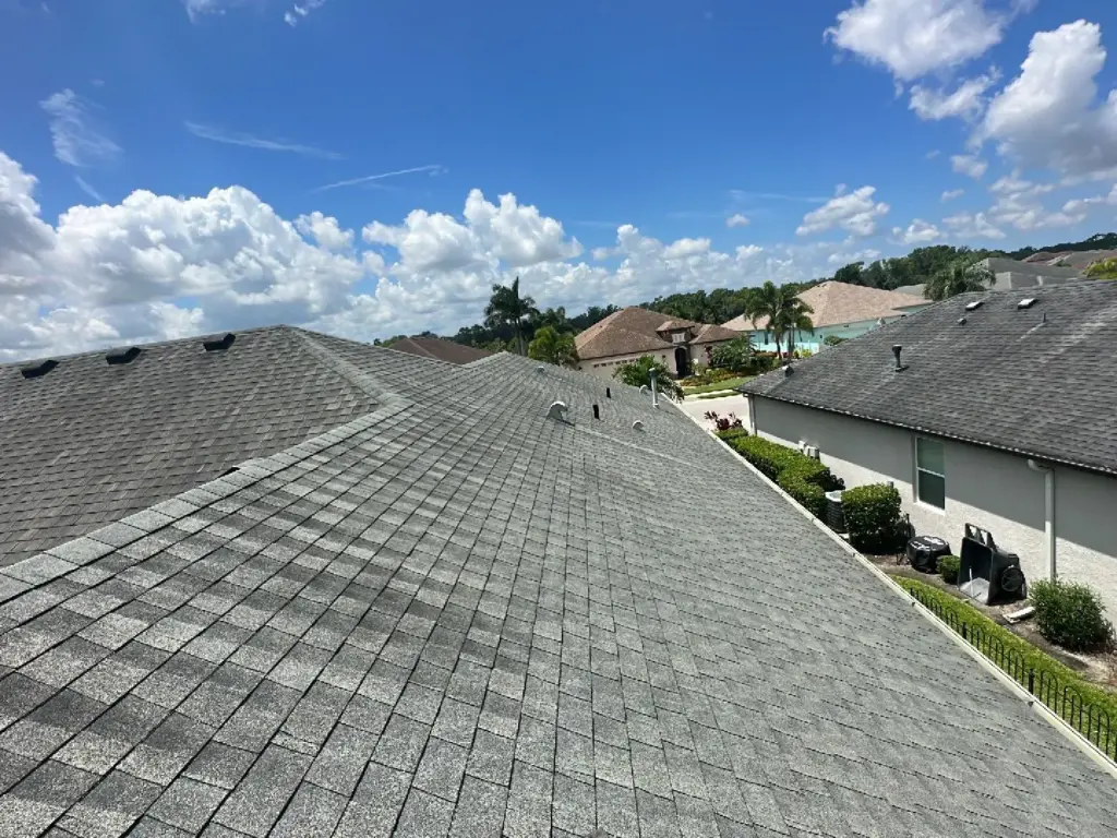Crew removing damaged shingles during a roof repair in the Tampa Bay area