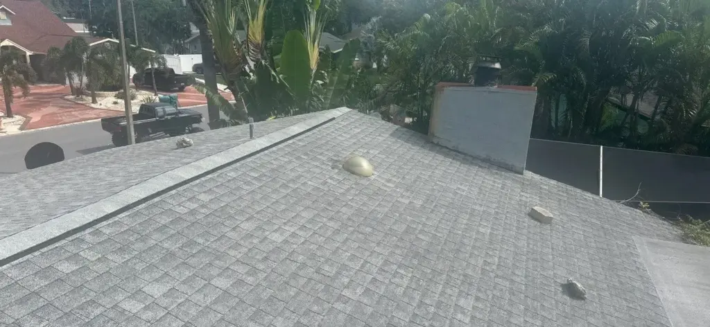 Roofer inspecting damaged section during roof repair in Pinellas County